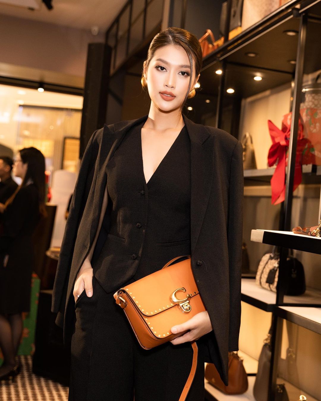 Miss Grand Vietnam Doan Thien An stands out in a stylish menswear and Coach bag design with a proudly attached C symbol